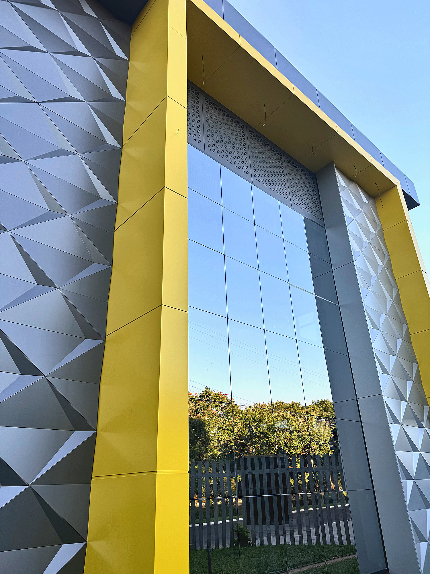 Faceted ACM panels beside a yellow returned frame