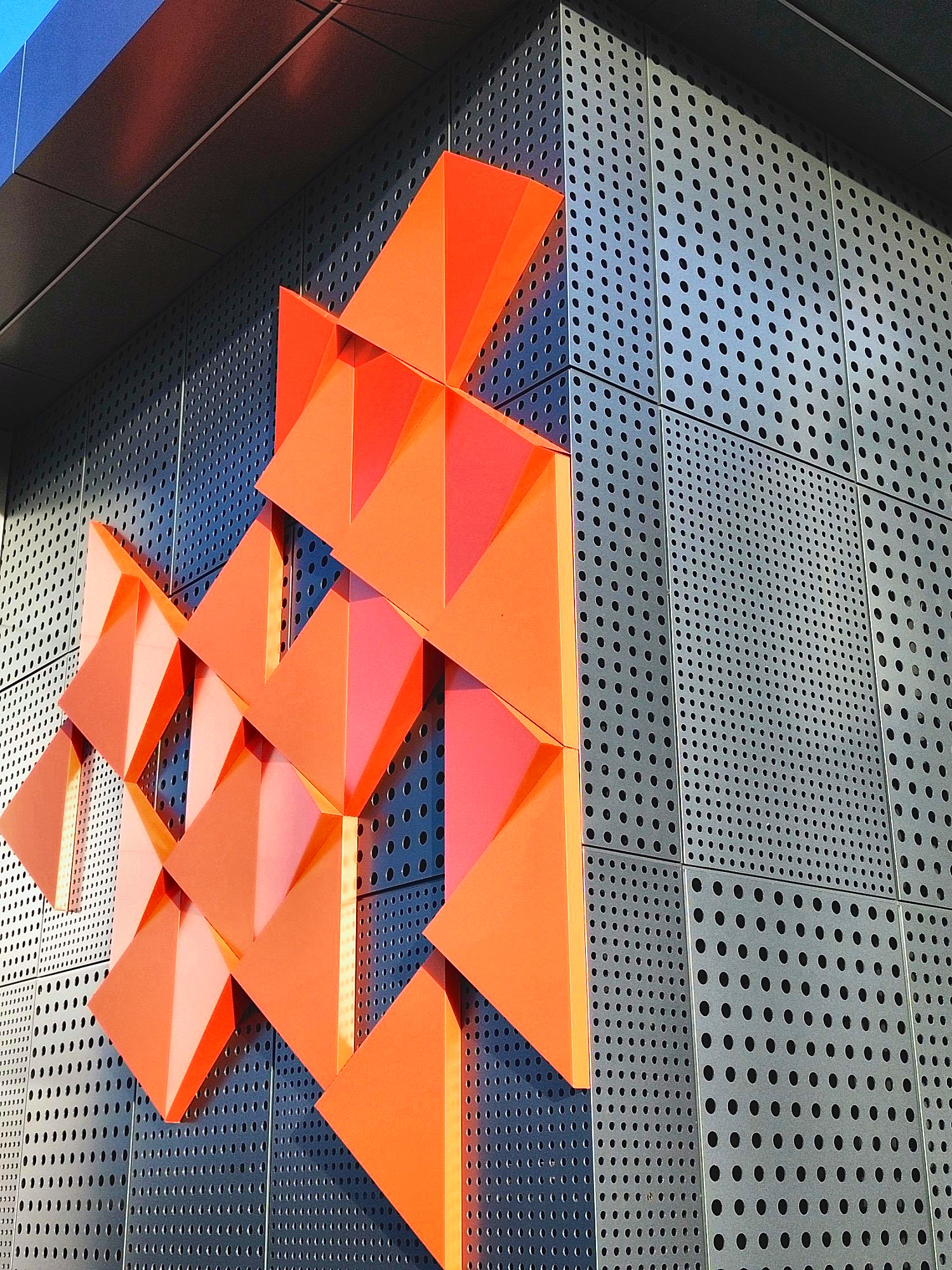 Orange folded pieces on perforated sheets