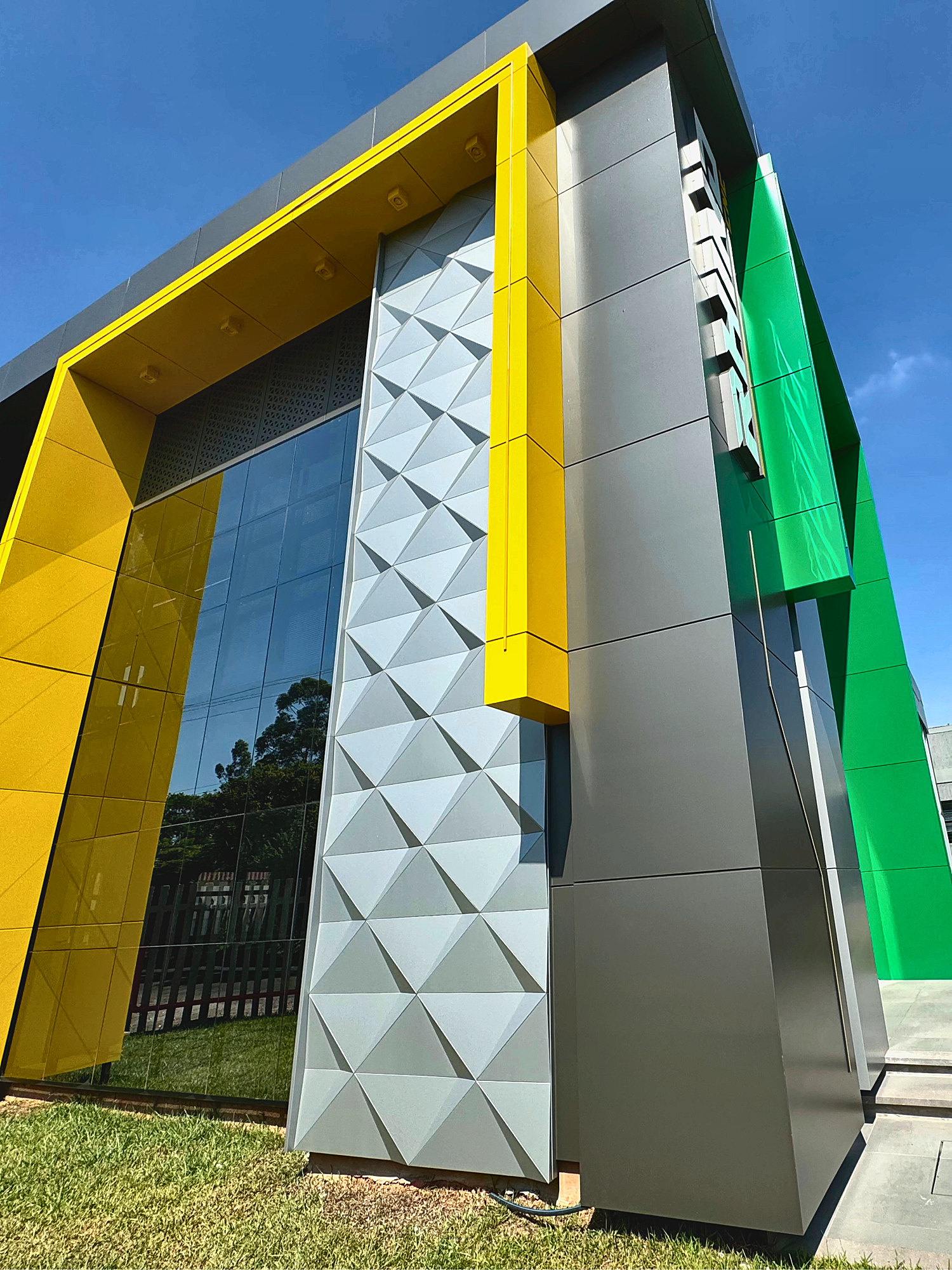 Faceted panels and a green ACM accent