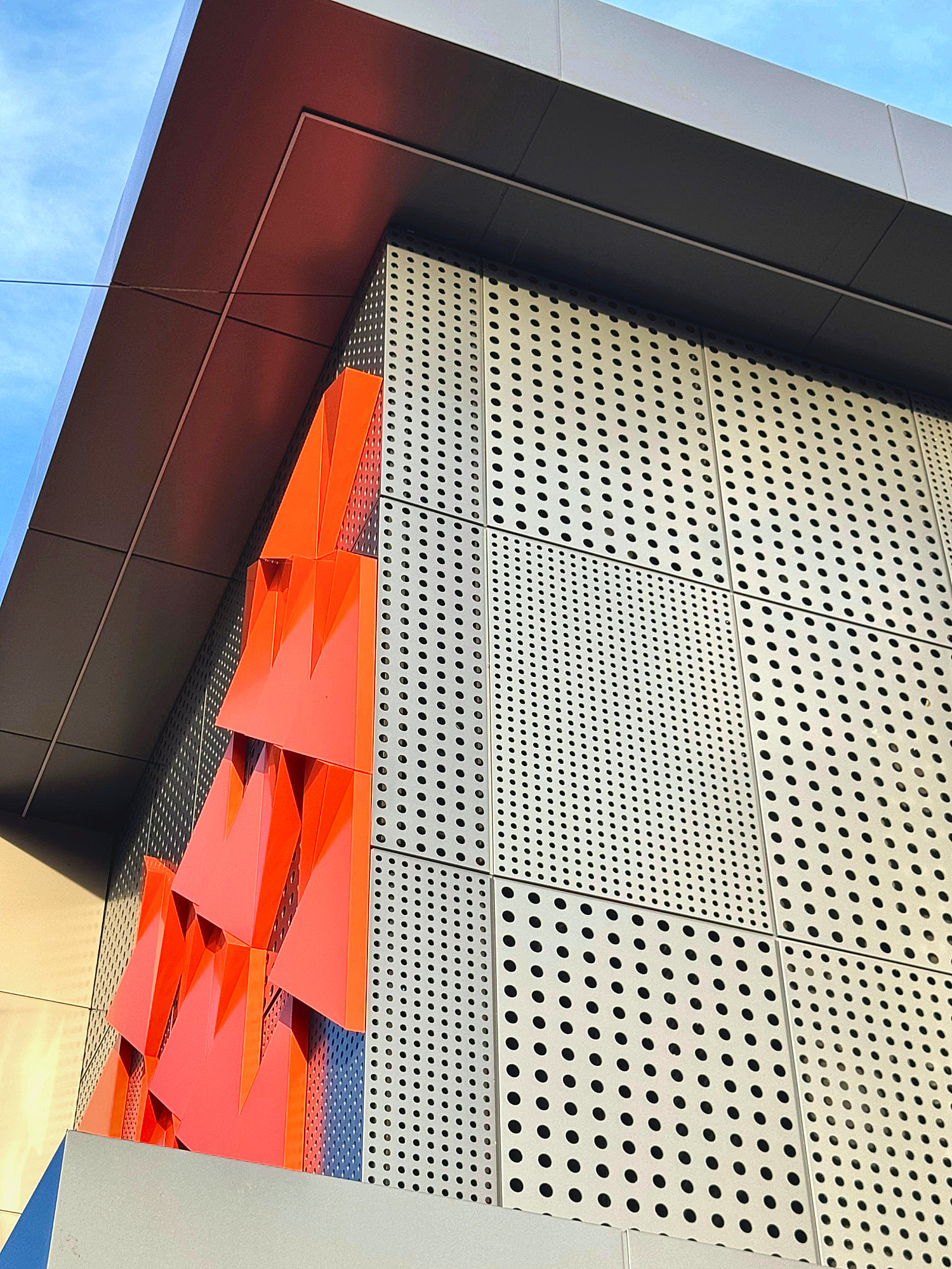 Orange folded pieces beside a perforated screen