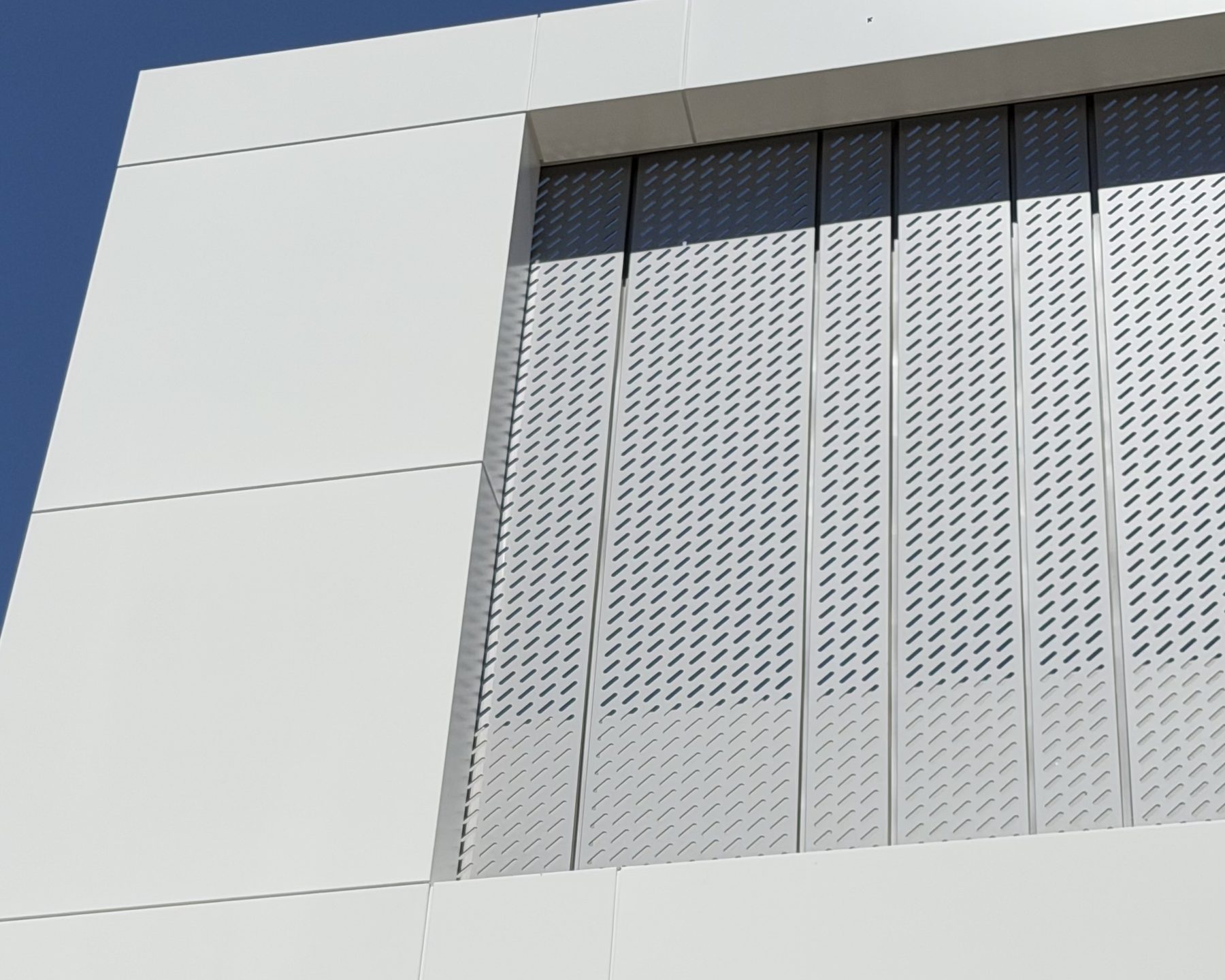 Perforated screen inside a white ACM frame